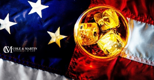 American flag with glass of liquor alcohol on top